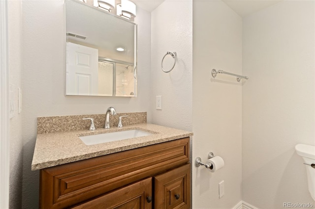 411 S Cody Ct, Lakewood, CO 80226 - bathroom featuring toilet, vanity, and an enclosed shower