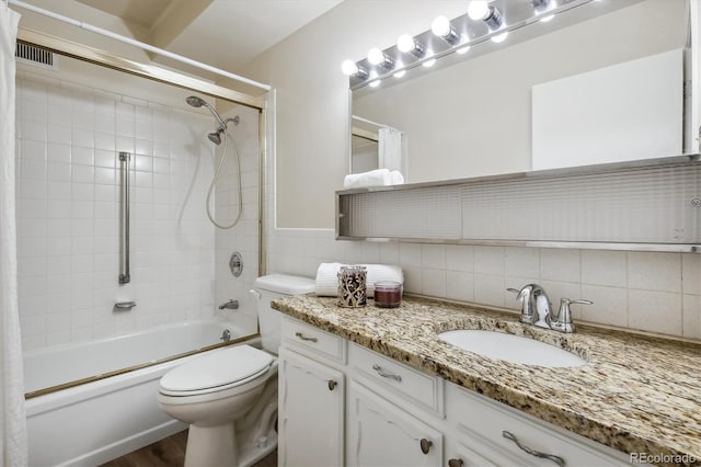 full bathroom with hardwood / wood-style floors, vanity, decorative backsplash, toilet, and shower / bath combo with shower curtain