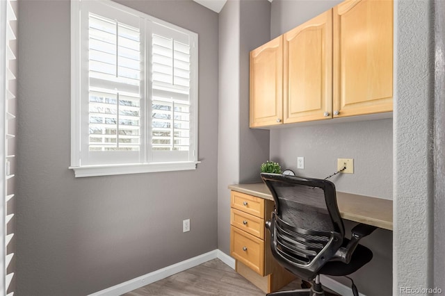 office area featuring light wood-style flooring and baseboards