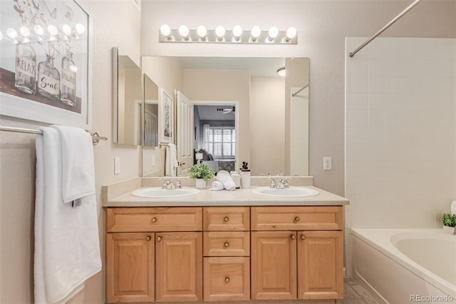 bathroom featuring double vanity, tub / shower combination, and a sink