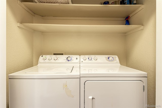 laundry room featuring washing machine and dryer, laundry area, and a textured wall