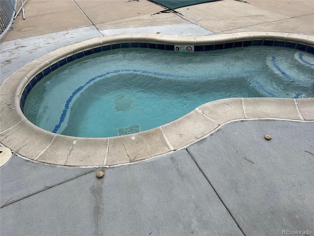 view of pool with an in ground hot tub