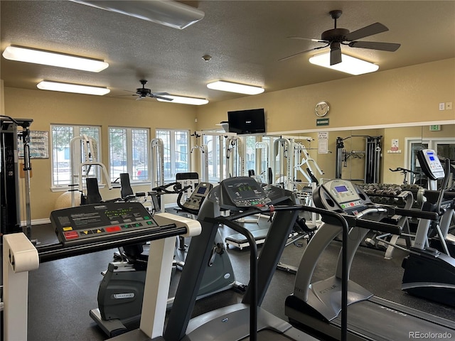 workout area featuring a textured ceiling, a ceiling fan, and baseboards