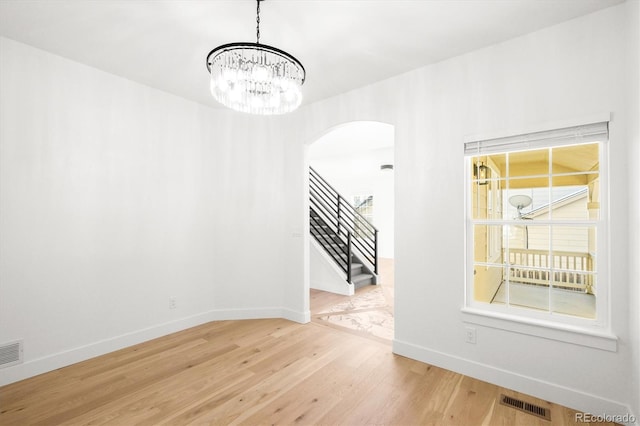 interior space with wood-type flooring and an inviting chandelier