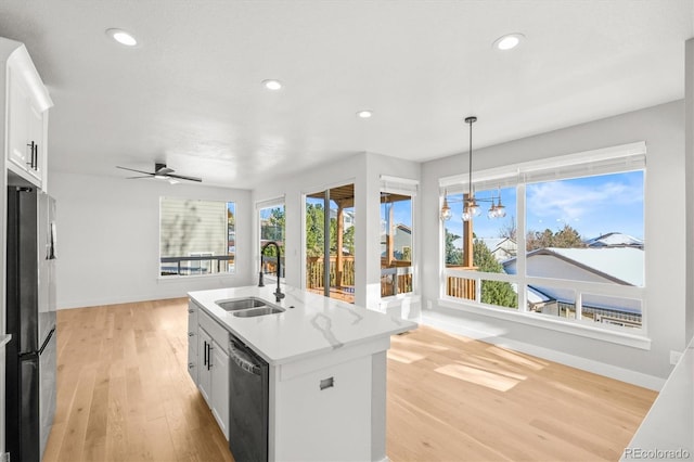 kitchen with sink, decorative light fixtures, a center island with sink, black dishwasher, and white cabinetry