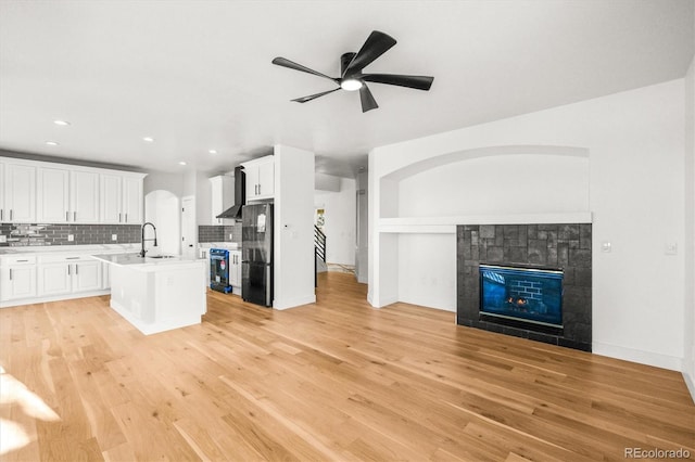 kitchen featuring a kitchen island with sink, light hardwood / wood-style flooring, white cabinets, and black appliances