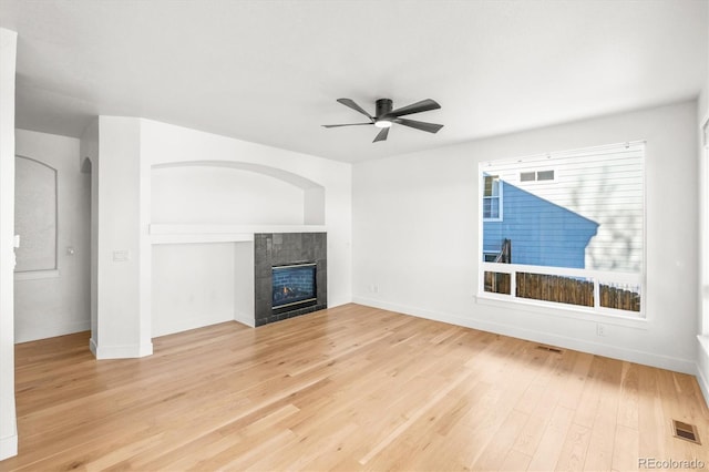 unfurnished living room featuring a fireplace, ceiling fan, and hardwood / wood-style floors