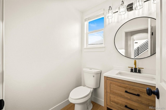 bathroom with toilet, vanity, and hardwood / wood-style flooring