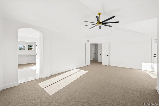 carpeted spare room featuring ceiling fan and vaulted ceiling