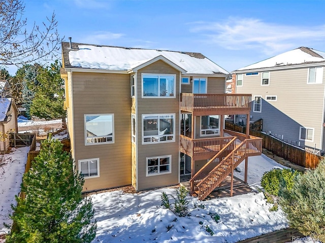 snow covered property with a wooden deck