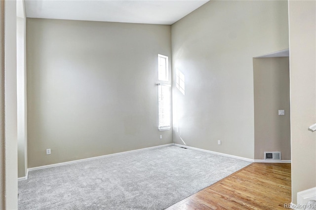 unfurnished room with lofted ceiling and hardwood / wood-style flooring