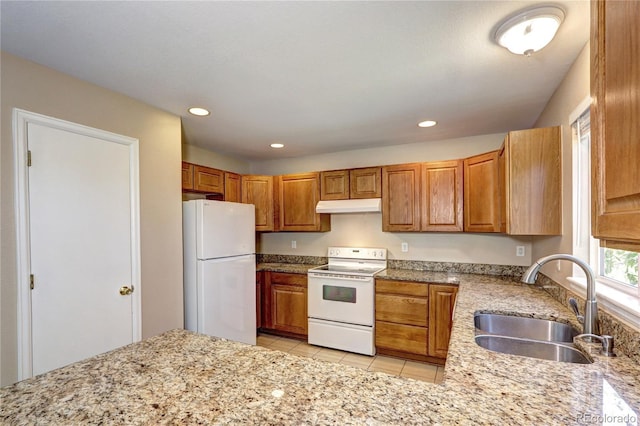 kitchen with light stone countertops, white appliances, light tile patterned flooring, and sink