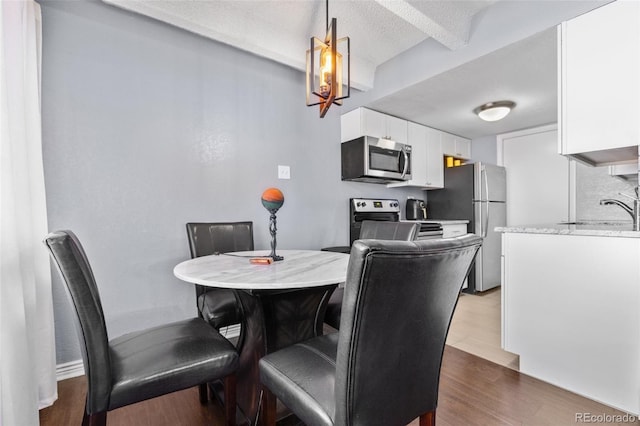 dining area featuring dark wood-style floors and a textured ceiling