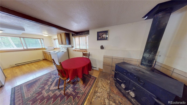 dining area featuring a textured ceiling, baseboard heating, and hardwood / wood-style flooring