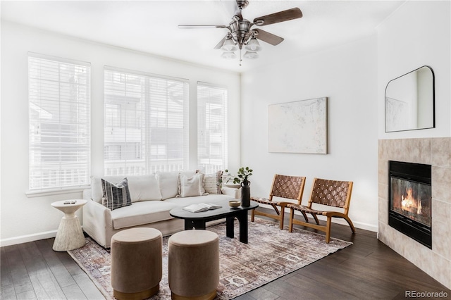 living room with dark hardwood / wood-style floors, ceiling fan, and a fireplace