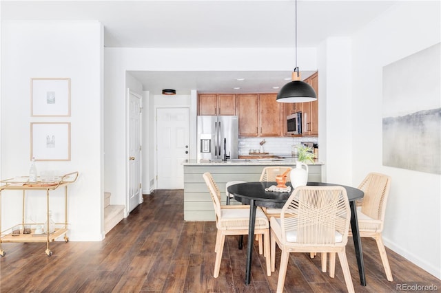 kitchen with sink, tasteful backsplash, decorative light fixtures, dark hardwood / wood-style flooring, and stainless steel appliances