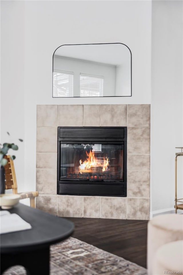 details with a tile fireplace and hardwood / wood-style floors