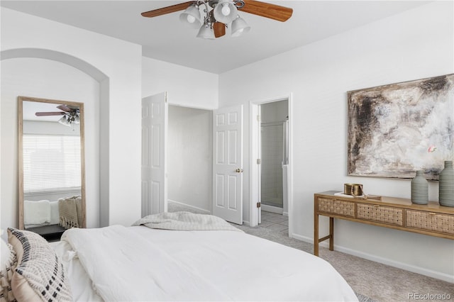 carpeted bedroom with connected bathroom and ceiling fan