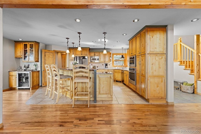 30717 Conifer Mountain Dr, Conifer, CO 80433 - kitchen featuring wine cooler, appliances with stainless steel finishes, recessed lighting, light wood finished floors, and a breakfast bar