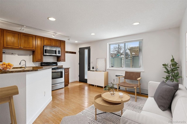 1 N Pearl St Unit 102, Denver, CO 80203 - living area featuring rail lighting, light wood-style flooring, a textured ceiling, a baseboard heating unit, and recessed lighting
