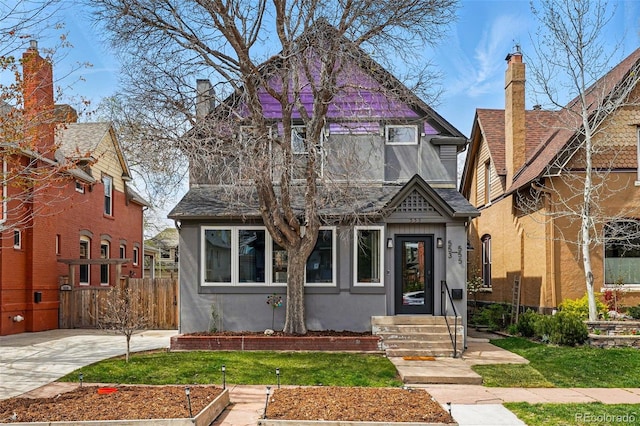 view of front of home with stucco siding, fence, and a chimney