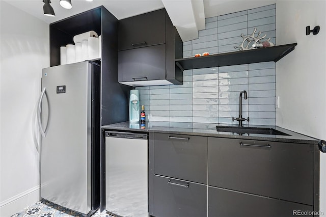 kitchen featuring freestanding refrigerator, open shelves, a sink, decorative backsplash, and dark stone countertops
