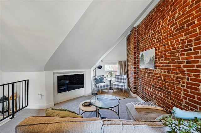 living area with carpet flooring, lofted ceiling, baseboards, and brick wall