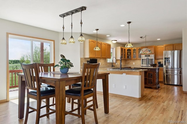 dining space with recessed lighting, light wood-style flooring, and baseboards