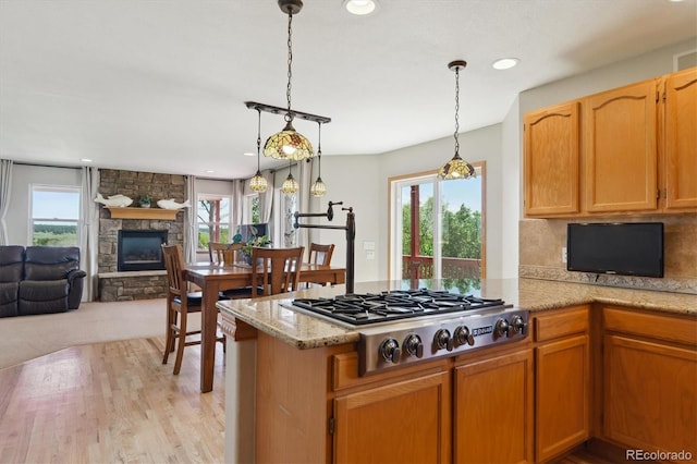kitchen with stainless steel gas stovetop, a fireplace, open floor plan, plenty of natural light, and recessed lighting