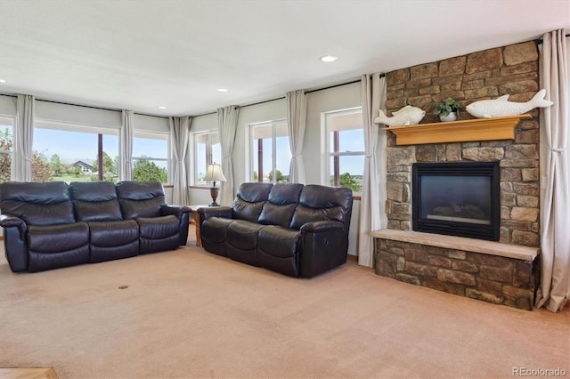 carpeted living area with a stone fireplace and recessed lighting