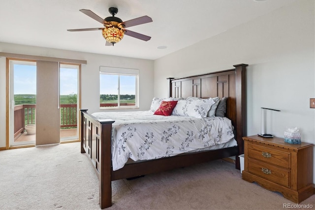 bedroom featuring access to outside, light colored carpet, and a ceiling fan