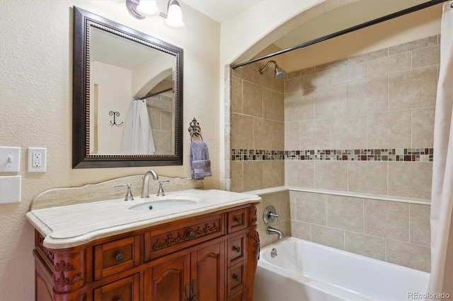 full bath featuring shower / tub combo, vanity, and a textured wall