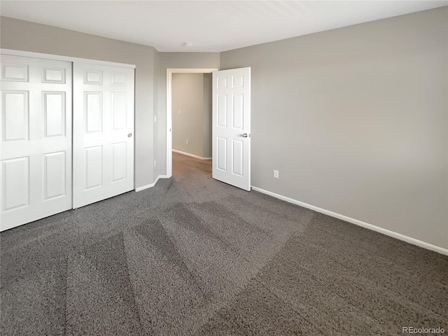 unfurnished bedroom featuring dark carpet and a closet