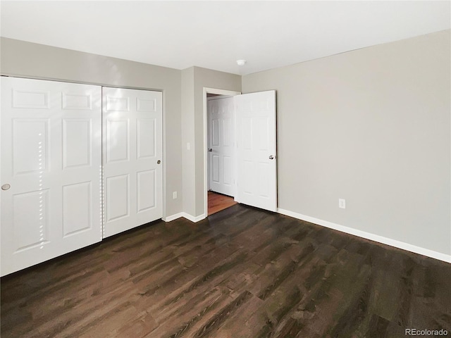 unfurnished bedroom with dark wood-type flooring and a closet