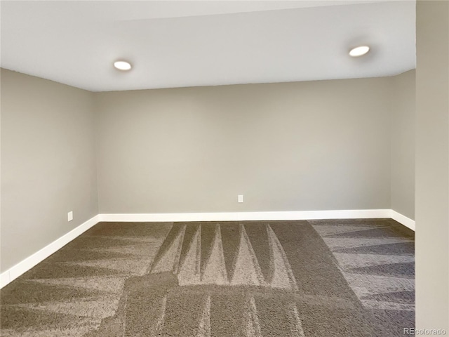 spare room with dark colored carpet