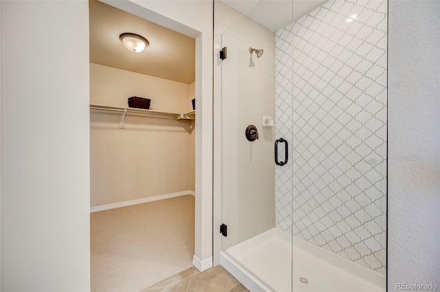 bathroom featuring a shower with shower door and a textured ceiling