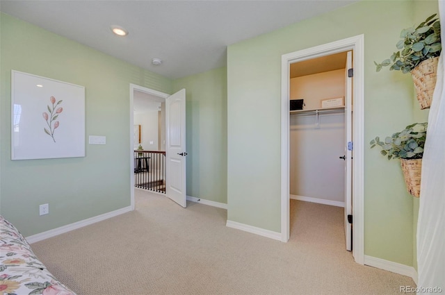 carpeted bedroom featuring a walk in closet and a closet