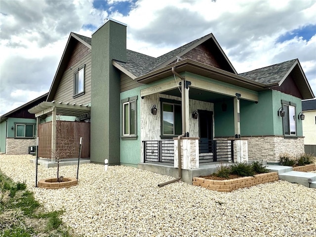 10704 Engelmann Ave, Salida, CO 81201 - view of side of home featuring covered porch, a pergola, a shingled roof, stone siding, and a chimney