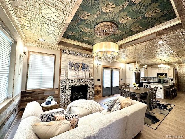 10704 Engelmann Ave, Salida, CO 81201 - living room featuring a chandelier, an ornate ceiling, light wood-style flooring, a fireplace, and french doors