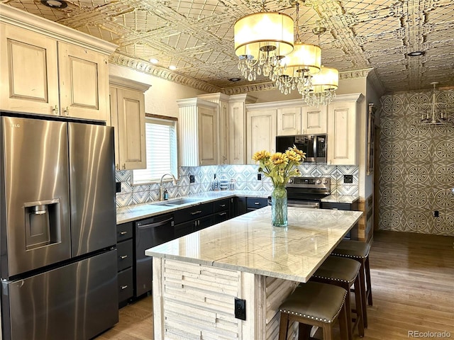 10704 Engelmann Ave, Salida, CO 81201 - kitchen with stainless steel appliances, a sink, an ornate ceiling, a chandelier, and light stone counters