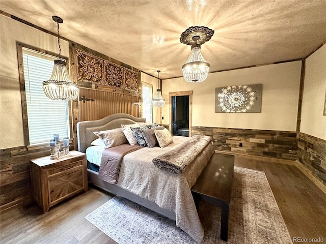 10704 Engelmann Ave, Salida, CO 81201 - bedroom with a chandelier, wood finished floors, wainscoting, and wooden walls