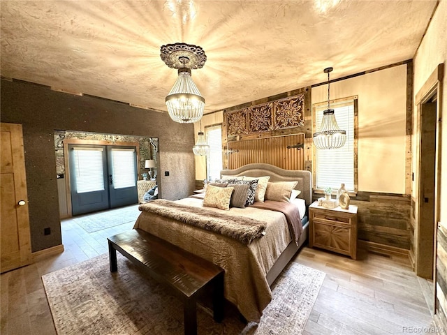 10704 Engelmann Ave, Salida, CO 81201 - bedroom with a chandelier, access to exterior, light wood finished floors, french doors, and wainscoting