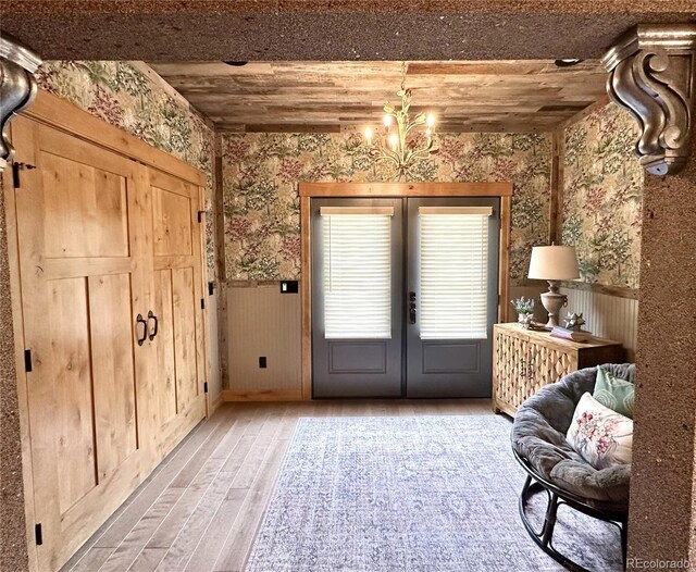10704 Engelmann Ave, Salida, CO 81201 - doorway to outside with french doors, wallpapered walls, a wainscoted wall, light wood finished floors, and a chandelier