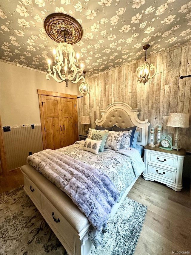 10704 Engelmann Ave, Salida, CO 81201 - bedroom featuring wooden walls, wood finished floors, and a chandelier