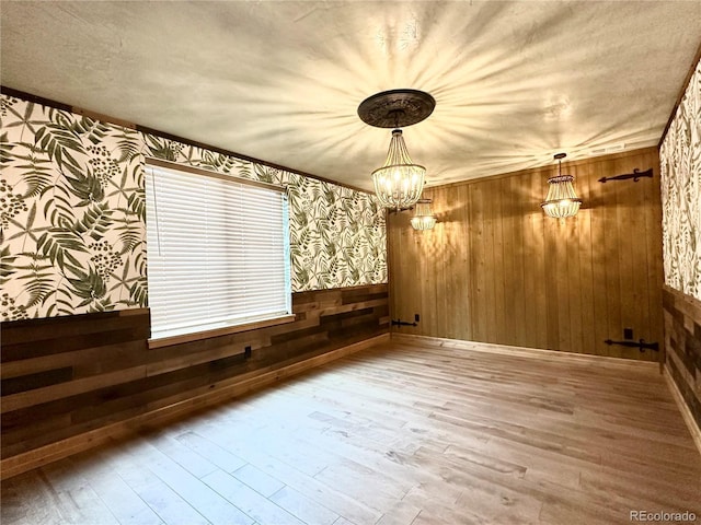 10704 Engelmann Ave, Salida, CO 81201 - unfurnished dining area featuring wallpapered walls, wood finished floors, wood walls, a chandelier, and a wainscoted wall