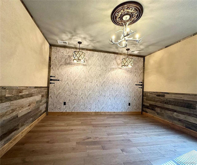 10704 Engelmann Ave, Salida, CO 81201 - unfurnished dining area with wood finished floors, a chandelier, wainscoting, and wood walls