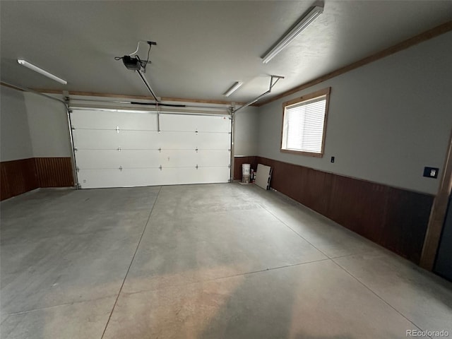 10704 Engelmann Ave, Salida, CO 81201 - garage featuring a wainscoted wall, wooden walls, and a garage door opener