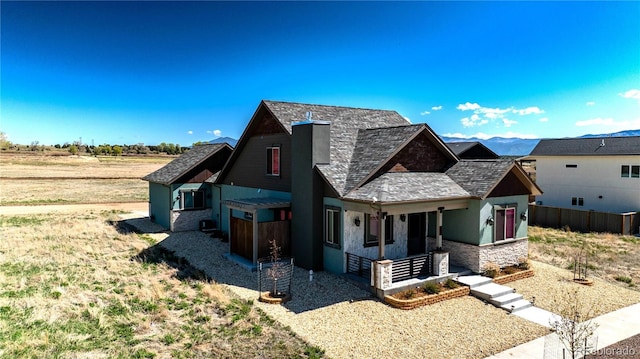 10704 Engelmann Ave, Salida, CO 81201 - view of front of house with stone siding, roof with shingles, stucco siding, and covered porch