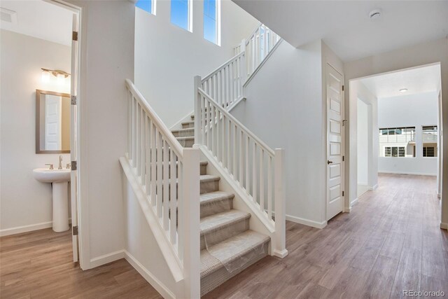 24563 E 34th Ave, Aurora, CO 80019 - stairs featuring wood finished floors, plenty of natural light, and baseboards