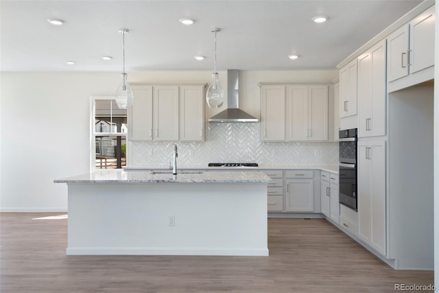 24563 E 34th Ave, Aurora, CO 80019 - kitchen with wall chimney range hood, a sink, backsplash, a kitchen island with sink, and recessed lighting